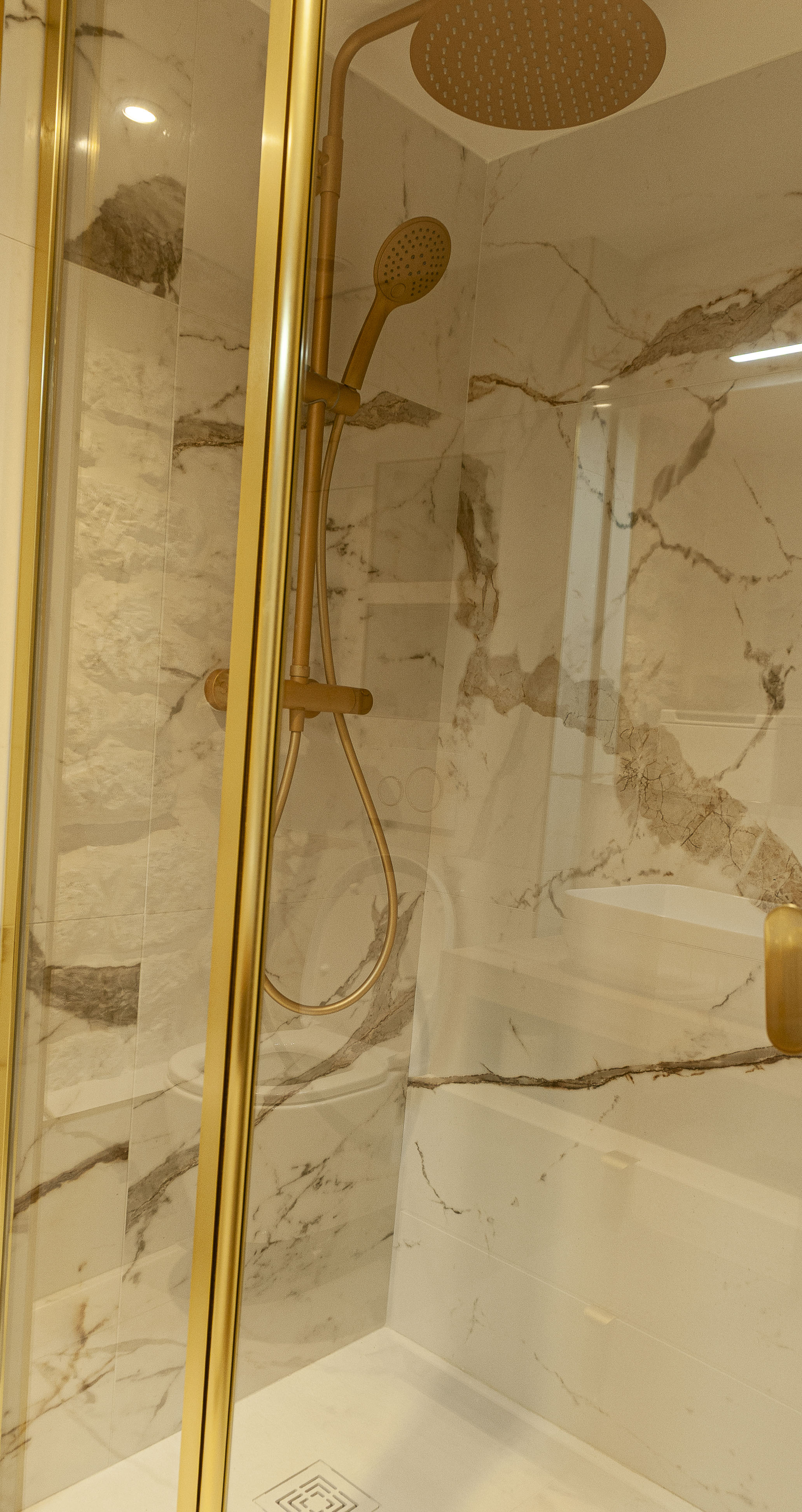 Douche italienne marbre Calacatta robinetterie dorée brossée Paris 2e